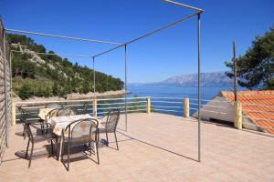un patio con mesa y sillas y vistas al agua en Apartments by the sea Cove Mala Pogorila, Hvar - 8953, en Bogomolje