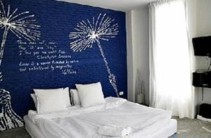 a bedroom with a bed with a blue wall with fireworks at White@Sea Resort in Ban Phe