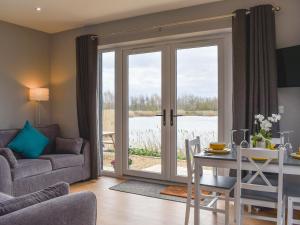 a living room with a table and a glass door at Fox Lodge - Uk30605 in Pidley
