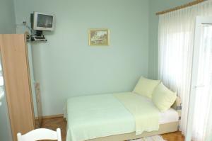 ein kleines Bett in einem Zimmer mit einem TV an der Wand in der Unterkunft Studio Vodice 4172a in Vodice