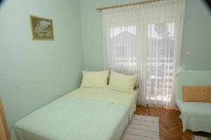 ein kleines Schlafzimmer mit einem Bett und einem Fenster in der Unterkunft Studio Vodice 4172a in Vodice