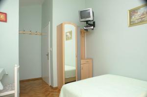 ein Schlafzimmer mit einem Spiegel, einem Bett und einem TV in der Unterkunft Studio Vodice 4172a in Vodice + 14 Fotos
