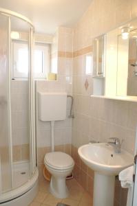 ein Badezimmer mit Toilette, Waschbecken und Dusche in der Unterkunft Studio Vodice 4172a in Vodice
