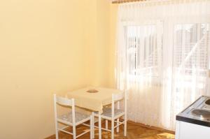 uma mesa e cadeiras numa cozinha com uma janela em Studio Vodice 4172d em Vodice