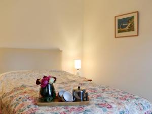 ein Tablett mit Geschirr und Blumen auf dem Bett in der Unterkunft Spey Cottage in Aberlour