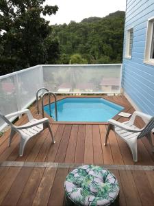 um deque com 2 cadeiras e uma piscina em Villas Smoothie Papaya em Le François