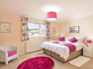 una camera con un grande letto e un tappeto rosa di Westburn a Comrie