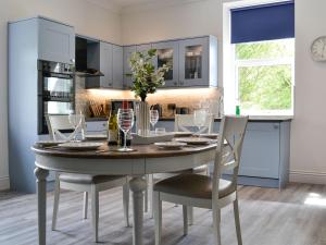 a kitchen with a table and chairs with wine glasses at Glenfield in Keighley