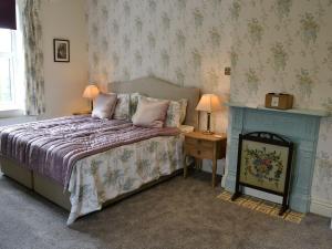 a bedroom with a bed and a table with two lamps at Glenfield in Keighley