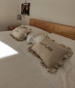 a bed with two pillows with the words kite on it at Ostuni home nature in Ostuni