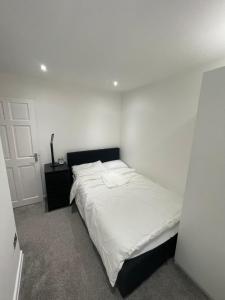 a white bedroom with a bed and a door at Tilbury Docks Rooms for Short letting in Tilbury