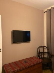 Habitación con TV de pantalla plana en la pared en Ap Praia dos anjos, en Arraial do Cabo