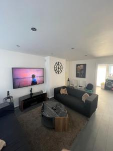 a living room with a couch and a flat screen tv at Tilbury Docks Rooms for Short letting in Tilbury