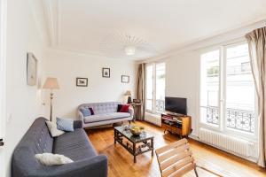 a living room with a couch and a tv at Large Apartment For A Family 2 Adults Max! in Paris