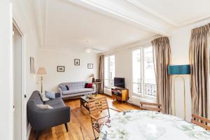 Large Apartment For A Family 2 Adults Max! في باريس: غرفة معيشة مع أريكة وطاولة