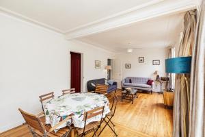 Large Apartment For A Family 2 Adults Max! في باريس: غرفة معيشة مع طاولة وكراسي وأريكة
