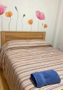 1 dormitorio con 1 cama con flores en la pared en Hermoso dpto amoblado, wifi, terraza,cochera pequeña y en San Miguel, en Lima