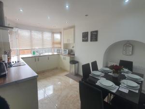 a kitchen and dining room with a table and chairs at Stylish and homey 3 bedroom house with free parking & Wi-Fi in Minworth