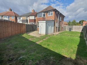 a yard with a fence and a house at Stylish and homey 3 bedroom house with free parking & Wi-Fi in Minworth