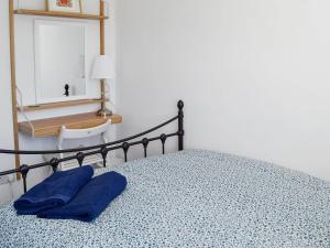 a bed with two blue pillows on top of it at Crown Courtyard Cottage in Grewelthorpe
