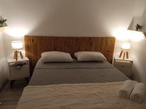 een slaapkamer met een bed met twee lampen op twee tafels bij Hotel Lobo de Mar - Las Heras in Mar del Plata