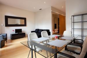 バルセロナにあるModern Center Apartmentsのリビングルーム(ガラスのテーブル、椅子付)