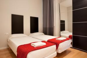 バルセロナにあるModern Center Apartmentsの鏡付きの小さな部屋のベッド2台