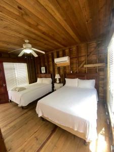 1 dormitorio con 2 camas y ventilador de techo en Ocean Breeze Villa Rentals, en Oak Ridge