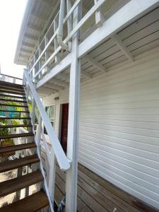 una barandilla blanca en la escalera lateral de un edificio en Ocean Breeze Villa Rentals, en Oak Ridge