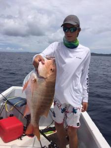 a man holding a large fish in a boat at Ocean Breeze Villa Rentals in Oak Ridge