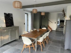 comedor con mesa de madera y sillas blancas en Attractive holiday home in Wallonie with garden en Gros-Fays