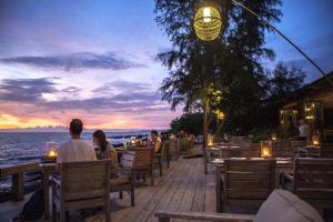 フーコックにあるマンゴー ベイ リゾートの夕日を眺めながら座る人々