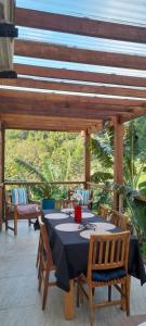 - une table et des chaises sur la terrasse dans l'établissement Recanto dos Pássaros, à Ilhabela