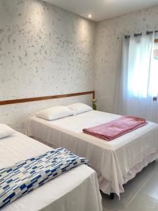 - une chambre avec 2 lits et une fenêtre dans l'établissement Casa de praia Prado Ba Doces magnólias, à Prado