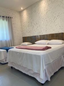 普拉多的住宿－Casa de praia Prado Ba Doces magnólias，一间卧室配有两张带白色床单和枕头的床。
