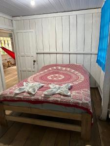 a bed in a room with two shoes on it at Flor de la selva in Puerto Nariño