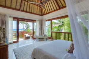 a bedroom with a bed and views of the ocean at Villa Tirta Nila by Elite Havens in Candidasa