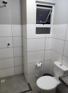 uma casa de banho com um WC e uma janela em Casa na praia com piscina em Luís Correia