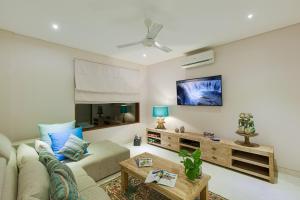 a living room with a couch and a tv at Villa Tirta Nila by Elite Havens in Candidasa