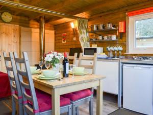 a dining room with a table and a kitchen at Robins Lodge in Westward