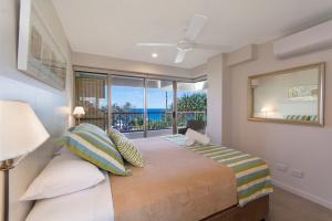 a bedroom with a bed with a view of the ocean at Costa Nova Holiday Apartments in Sunshine Beach