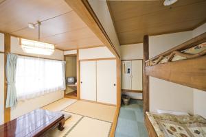 a room with two bunk beds and a window at Alpine Inn Mizushiro in Matsumoto