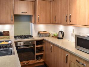 a kitchen with wooden cabinets and a stove top oven at Prospect Terrace in Kendal