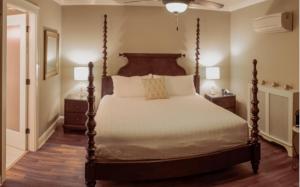 a bedroom with a large bed with a wooden headboard at Crown Mansion Boutique Hotel & Villas in Qualicum Beach +46 photos