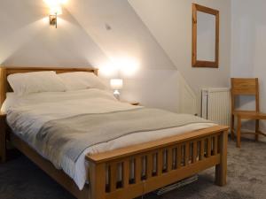 a bedroom with a large bed with a wooden frame at Lower Sycamore Cottage in Ambleside