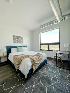 a white bedroom with a large bed and a window at Sleepover 1BD 1BA Des Moines Apartments in Des Moines