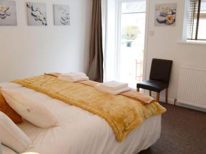 a bedroom with a large bed with towels on it at Beach Cottage in Nairn