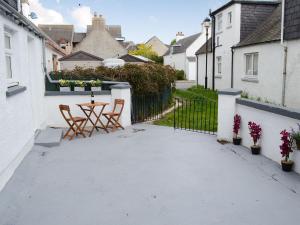 a patio with chairs and a table in a house at Beach Cottage in Nairn