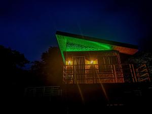 een gebouw met 's nachts groen licht bij Caliraya Ecoville Recreation and Farm Resort in Cavinti