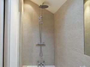 a shower with a shower head in a bathroom at Easter Cottage in Bamford